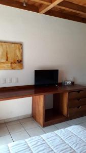 een houten bureau met een televisie aan de muur bij Hotel Pez Vela in Manzanillo