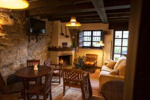 a living room with a couch and a table and a fireplace at Casa Asprón in Covadonga