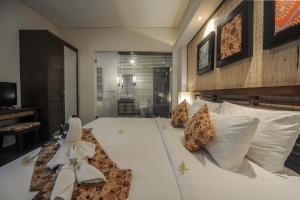 a bedroom with a large white bed with white pillows at Gaing Mas Jimbaran Villas by Gaing Mas Group in Jimbaran