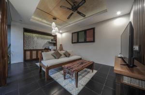 a living room with a couch and a tv at Gaing Mas Jimbaran Villas by Gaing Mas Group in Jimbaran