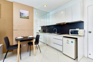 a small kitchen with a table and a microwave at Paradise Park by Tech in Jomtien Beach
