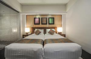 a hotel room with two beds and two lamps at Gaing Mas Jimbaran Villas by Gaing Mas Group in Jimbaran