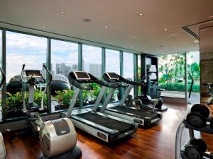 un gimnasio con equipo cardiovascular en un edificio con ventanas en The Fullerton Bay Hotel Singapore, en Singapur