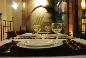 einen Tisch mit zwei Tellern und zwei Weingläsern in der Unterkunft Riad Gallery 49 in Marrakesch