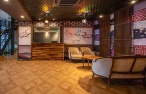 a lobby with chairs and a table and a stage at Residence Hotel Takayama Station in Takayama
