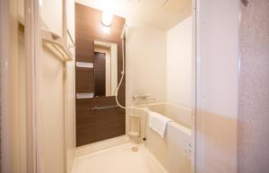 a bathroom with a shower and a sink at Residence Hotel Takayama Station in Takayama