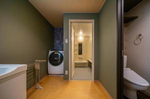 a bathroom with a toilet and a tv in it at Residence Hotel Takayama Station in Takayama +41 photos