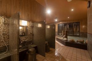 een grote badkamer met een douche en een wastafel bij Dormy Inn Premium Fukui Natural Hot Spring in Fukui
