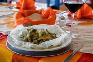 une assiette de nourriture sur une table avec un verre de vin dans l'établissement Hotel De La Loma, à Tlaxcala de Xicohténcatl