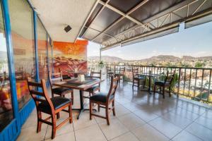 un restaurante con mesas y sillas y un balcón en Hotel De La Loma en Tlaxcala de Xicohténcatl