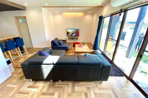 a living room with a black couch and a table at KANRA ichinomiya in Ichinomiya