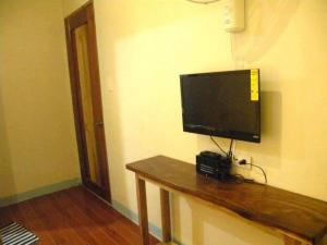 a television on a wall with a camera on a table at Casa Montemar Bed and Breakfast in Coron