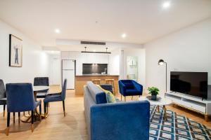 a living room filled with furniture and a tv at Brisbane One Apartments in Brisbane