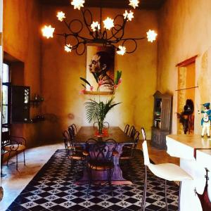 a dining room with a table and chairs and a chandelier at Hacienda Sacnicte in Izamal