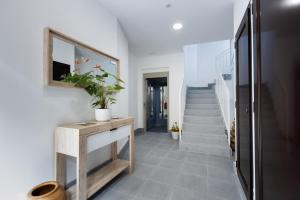 pasillo con paredes blancas y escalera con espejo en Apartamentos Turísticos San Lorenzo, en Nájera