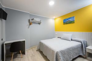 una camera con un letto e una parete gialla di Apartamentos Turísticos San Lorenzo a Nájera