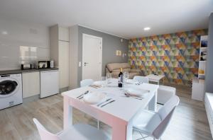 uma sala de jantar branca com uma mesa e cadeiras brancas em Apartamentos Turísticos San Lorenzo em Nájera