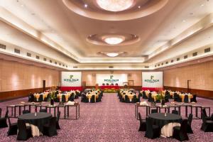 una sala banchetti con tavoli e sedie in una stanza di Royal Palm Hotel & Conference Center Cengkareng a Giacarta