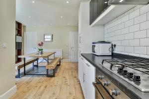 a kitchen with a stove and a table in it at Refurbished Central Premium Property in Sheffield