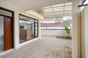 an empty house with a large window and a patio at Super OYO 3209 Hegarbudhi Residence in Bandung