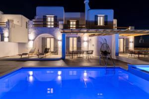 une villa avec une piscine la nuit dans l'établissement NAXIAN SUNSET VILLAS, à Naxos Chora