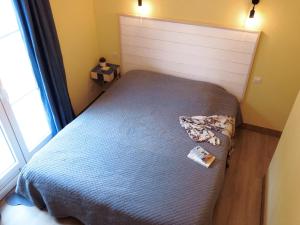 a bedroom with a bed with a blue blanket and a window at La Villa Les Hespérides in Grimaud +24 photos