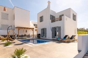 una villa con piscina di fronte a una casa di NAXIAN SUNSET VILLAS a Naxos Chora