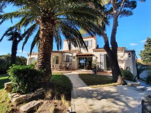 une maison avec deux palmiers devant elle dans l'établissement La Villa du Petit Port, à Martigues