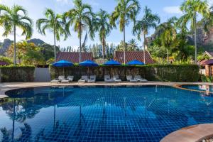- une piscine avec des chaises, des parasols et des palmiers dans l'établissement Railay Bay Resort & Spa, à Railay Beach