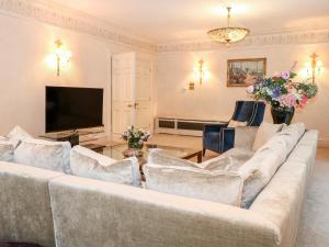 a living room with a couch and a tv at Gleneagles in Ascot