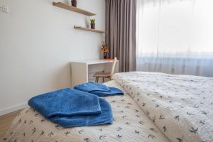 Un dormitorio con una cama con toallas azules. en City apartment Poprad, en Poprad