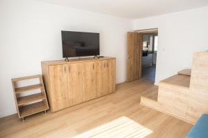 una sala de estar con TV de pantalla plana en un armario de madera en City apartment Poprad, en Poprad