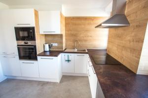 a kitchen with white cabinets and a sink at City apartment Poprad in Poprad