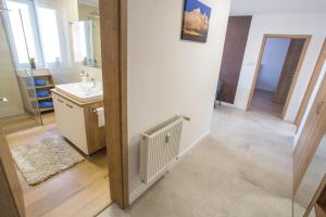 a bathroom with a sink and a white radiator at City apartment Poprad in Poprad +11 photos