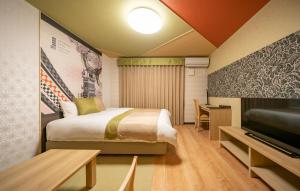 a bedroom with a bed and a television at Residence Hotel Takayama Station in Takayama