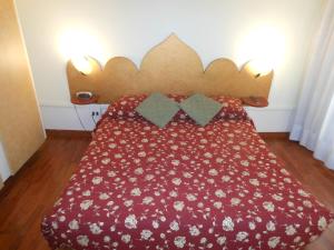 a bed with a red bedspread with flowers on it at Cà Del Dose in Venice