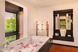 a bathroom with a bath tub and a window at Jetwing Lagoon in Negombo