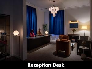 two people sitting at a reception desk in a hotel room at UNWIND HOTEL & BAR OTARU in Otaru