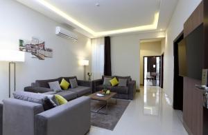 فندق كود العربية Kud Al Arabya Apartment Hotel في خميس مشيط: غرفة معيشة مع أريكة وتلفزيون