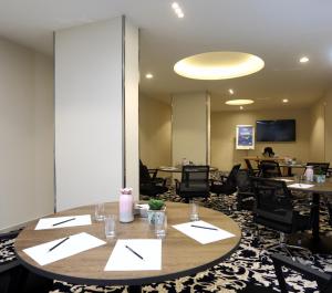 فندق كود العربية Kud Al Arabya Apartment Hotel في خميس مشيط: قاعة اجتماعات مع طاولات وكراسي وطاولة