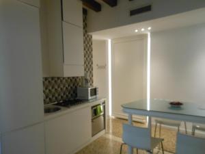 a kitchen with a counter and a table with chairs at Appartamenti A San Marco in Venice