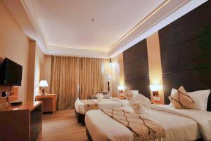 a hotel room with two beds and a television at Bindiram Express by ShriGo Hotels in Sītāpur Mūāfi