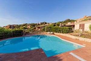 una gran piscina azul en un patio en Ginepro Arancione, en Li Valcaggi