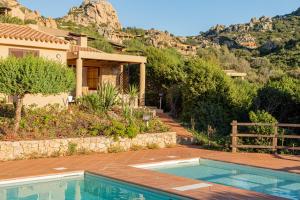 una casa con piscina frente a una montaña en Ginepro Arancione, en Li Valcaggi