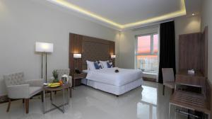 a hotel room with a large white bed and a table at شقق كود العربية للشقق الفندقيه Kud Al Arabya Apartment Hotel in Khamis Mushayt +14 photos