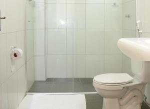 a white bathroom with a toilet and a sink at Requinte Hotel in Altamira +35 photos
