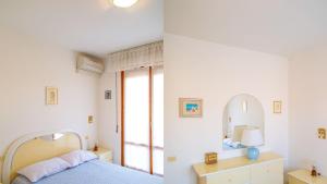 um quarto com uma cama e um espelho em Appartamento Il Marinaio em Porto Azzurro