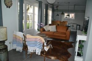 sala de estar con sofá y sillas con alfombra en Mourits Hoeve, en Woerden