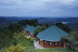 una fila de casas con techo verde en una colina en Top of The World Lodge, en Kikangala