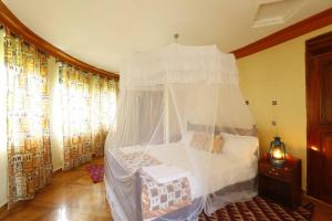 1 dormitorio con 1 cama con dosel en Top of The World Lodge, en Kikangala